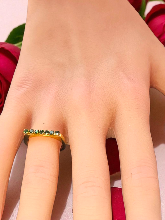 Bague dorée sertie de pierres vertes scintillantes